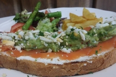 Tosta de salmón con crema de queso, guacamole, y mimosa de huevo